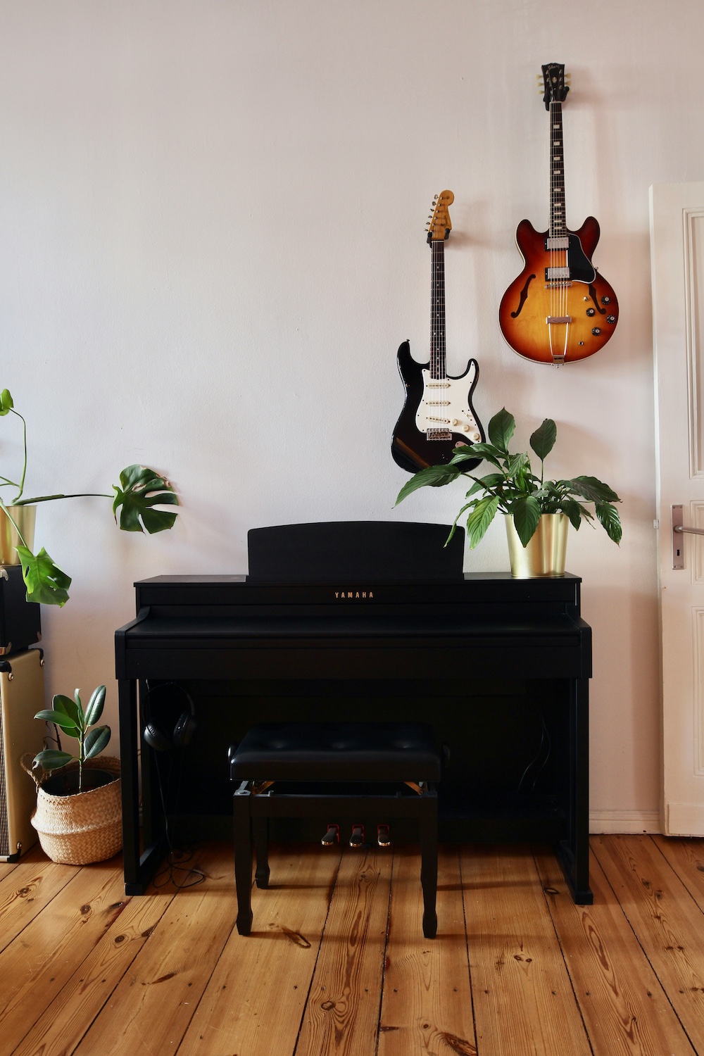 Black Yamaha piano with guitars mounted on the wall