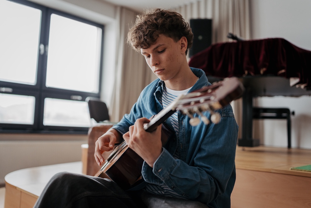 Teenager playing an acoustic guitar in a studio