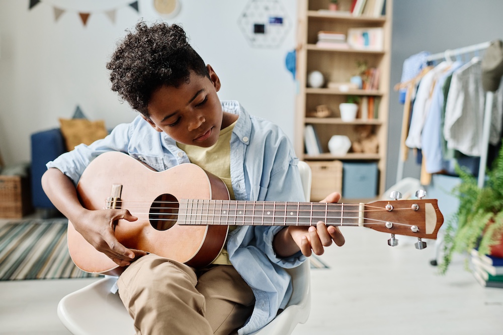 Young boy playing a ukulele